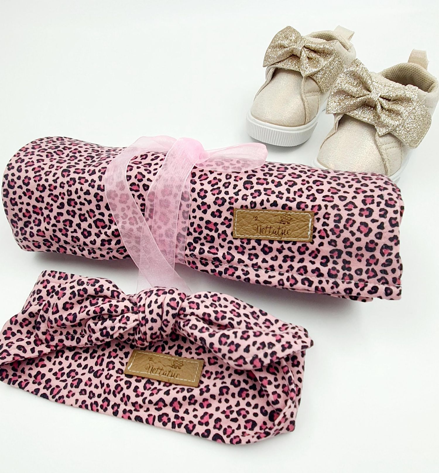 Pink leopard print headbands with sparkly bow accents arranged in a row.