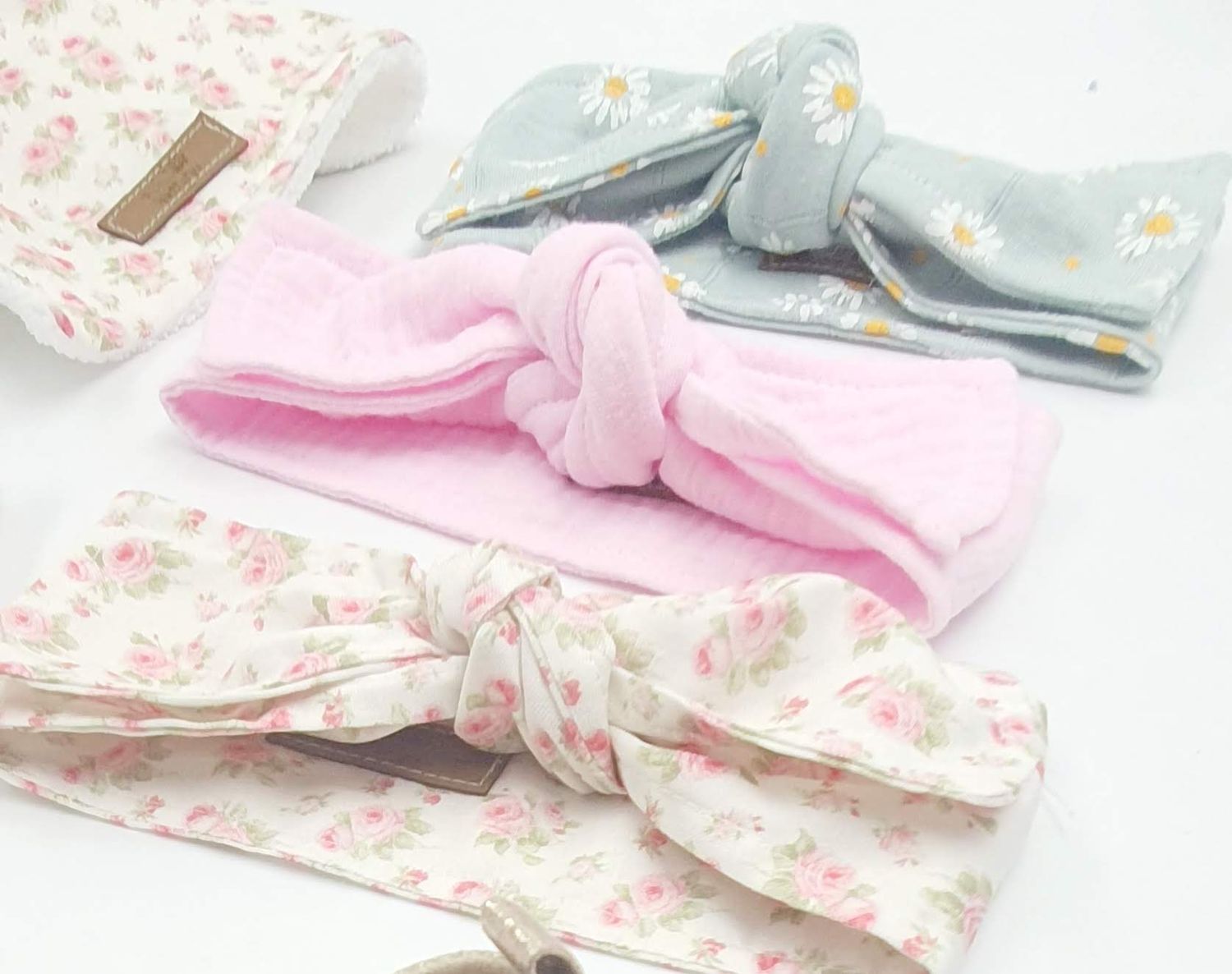 Collection of soft pink and blue floral headbands with matching bows.