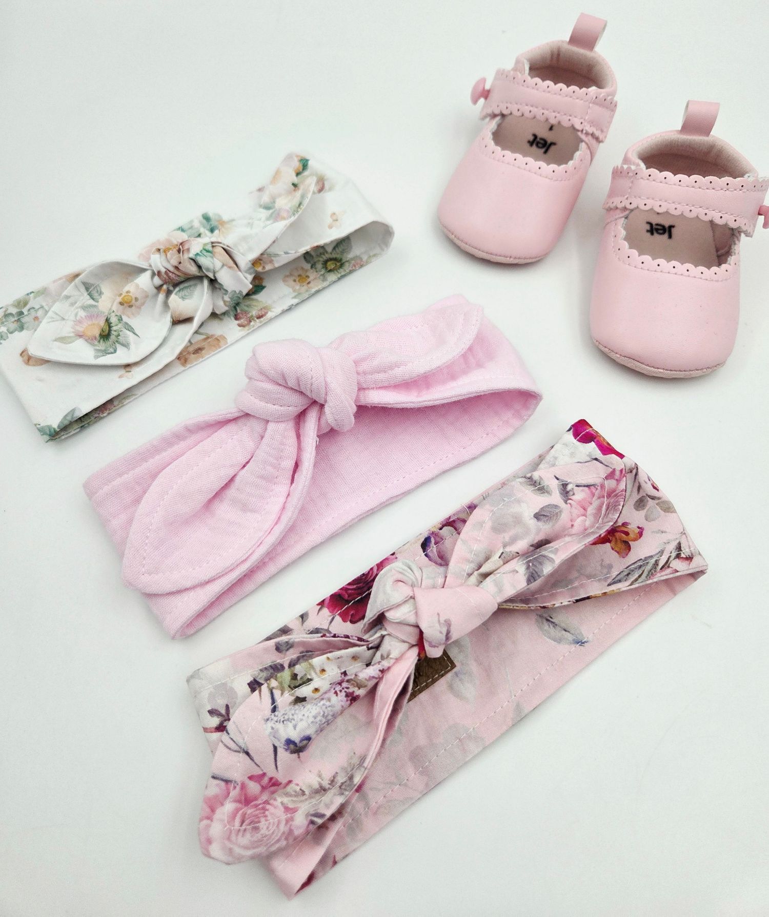 Pink baby girl set featuring floral headbands, soft shoes, and matching accessories.
