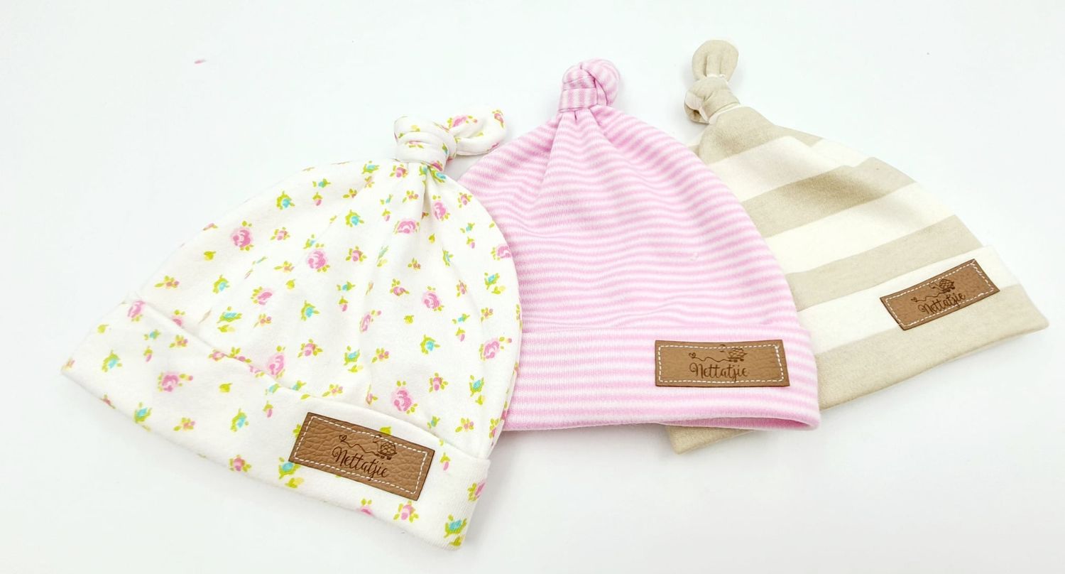 Baby headbands and accessories in soft pink and floral patterns arranged together.