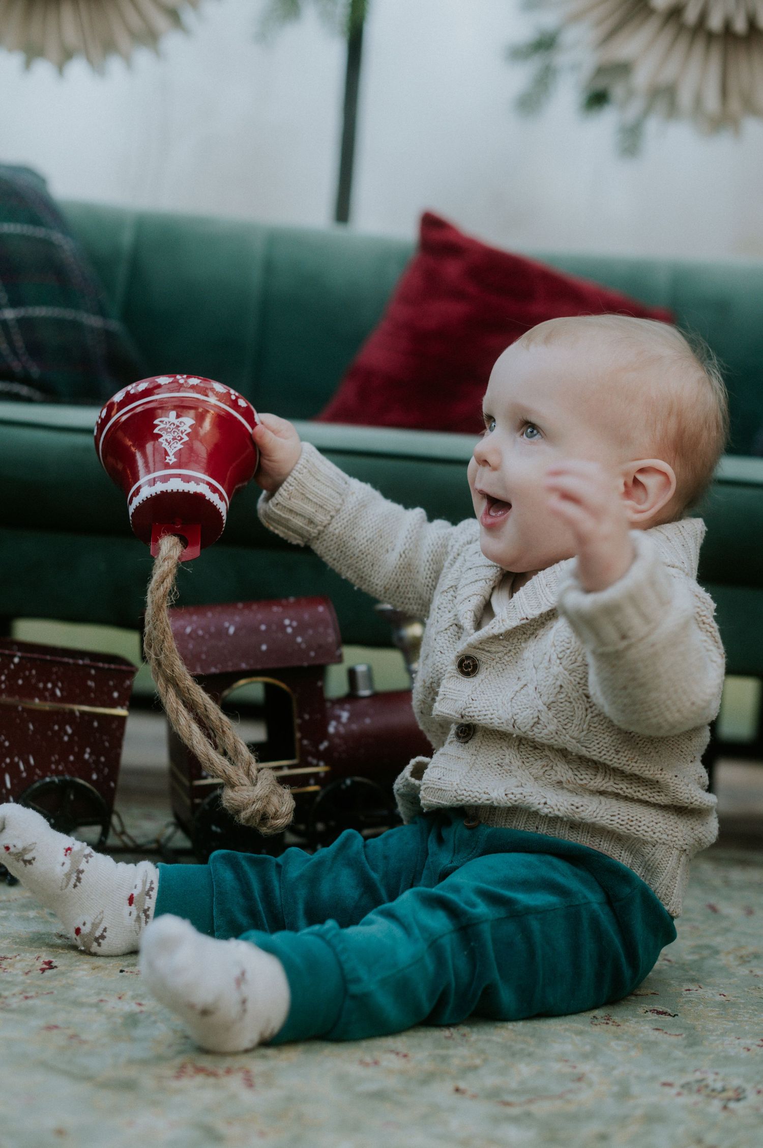 A collection of photos showing a baby in a cream sweater laying sideways drinking from a glass bottle.