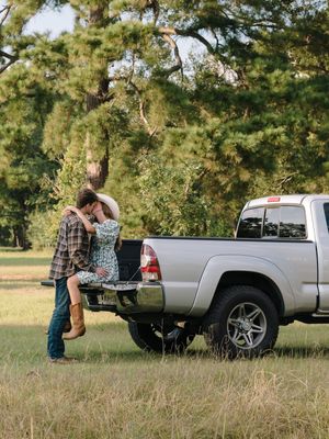 A series of photos showing two people examining the cargo bed of a silver pickup truck in an outdoor field setting.