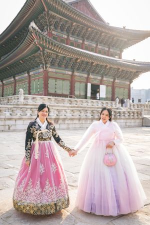 Traditional Korean hanbok dresses on display at Gyeongbokgung Palace courtyard in soft sunlight.