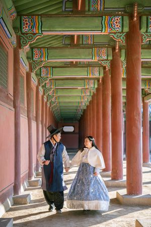 Traditional Korean palace corridor with painted wooden pillars and ornate architectural details.