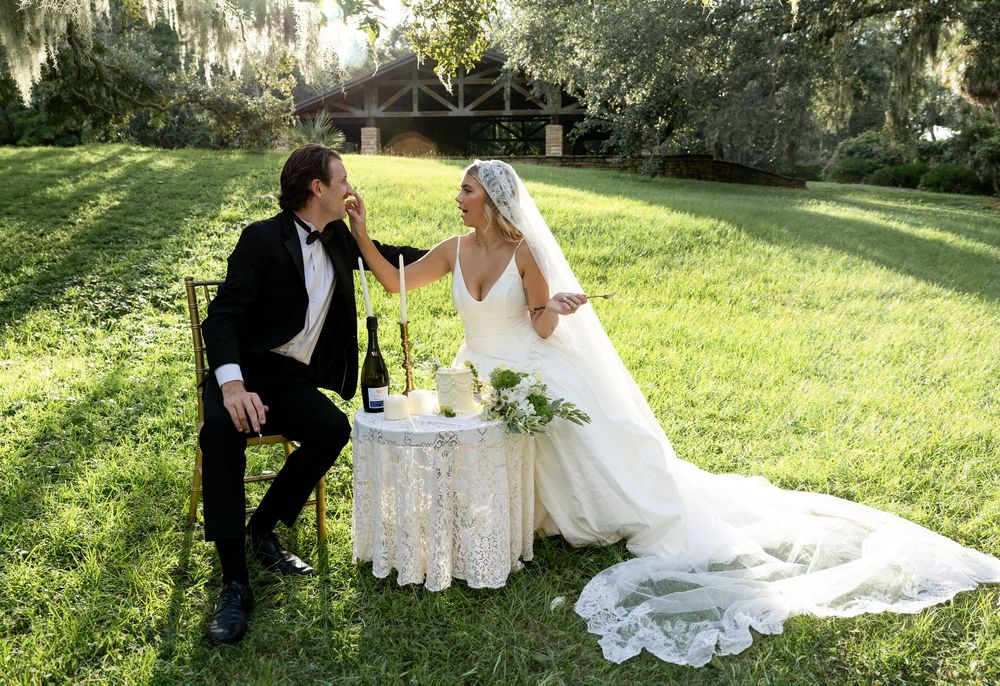 Couple celebrates their wedding day with an elegant outdoor tea service in a lush garden setting.