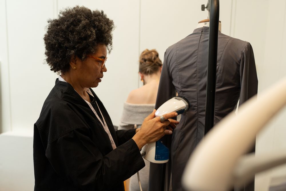 A designer steaming garments before the fashion show at London Fashion Week