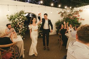 Bride and groom entering their outdoor wedding reception at La Cotte