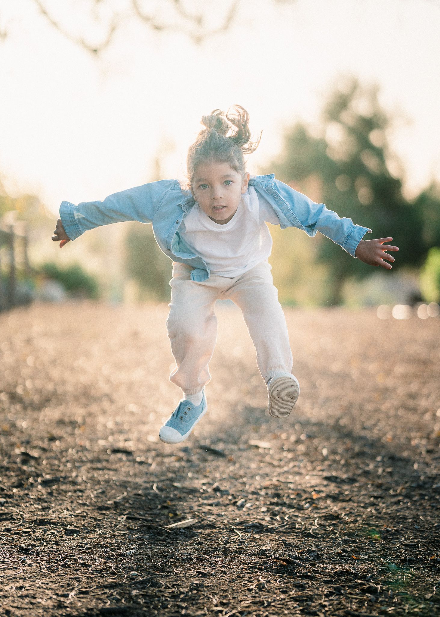 Full body shot of boy jumping in the air and looking straight into the lens - Newport Beach Family Photographer