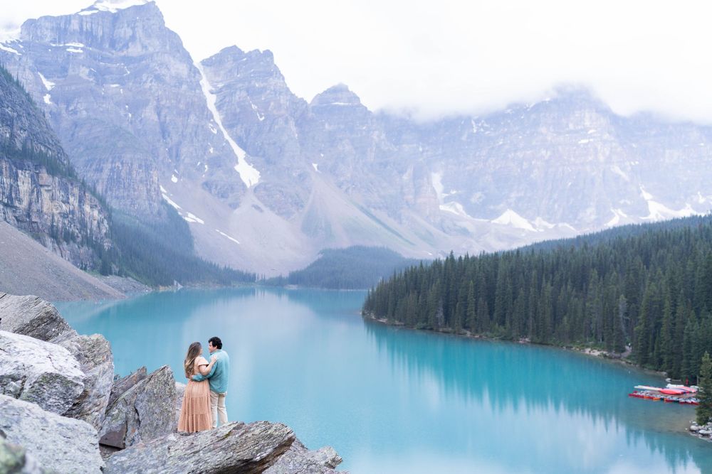 Stunning panoramic view of turquoise Moraine Lake surrounded by snow-capped Rocky Mountains in Banff National Park, Canada.