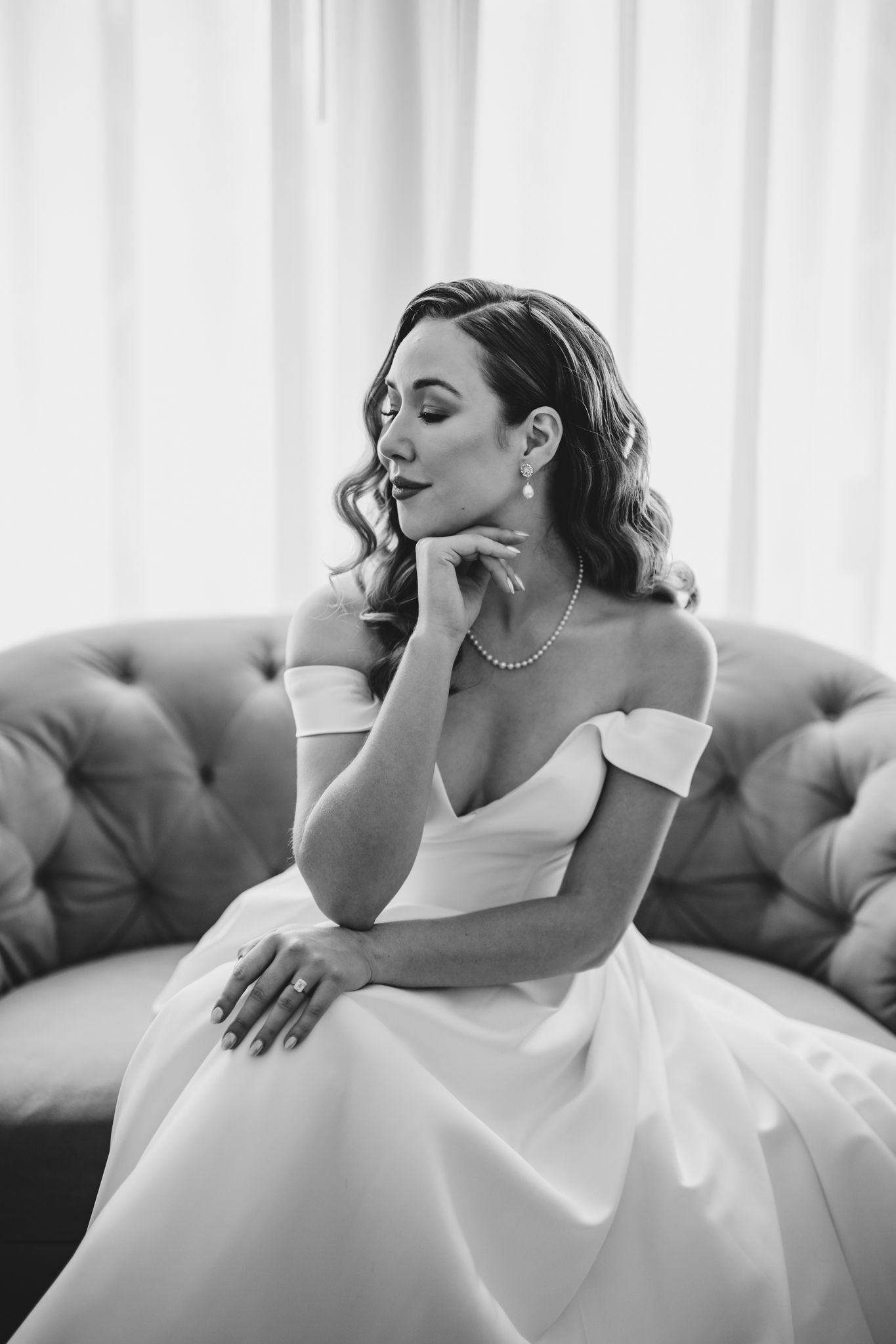 Candid bridal portraits showing joyful moments on a grey tufted sofa.