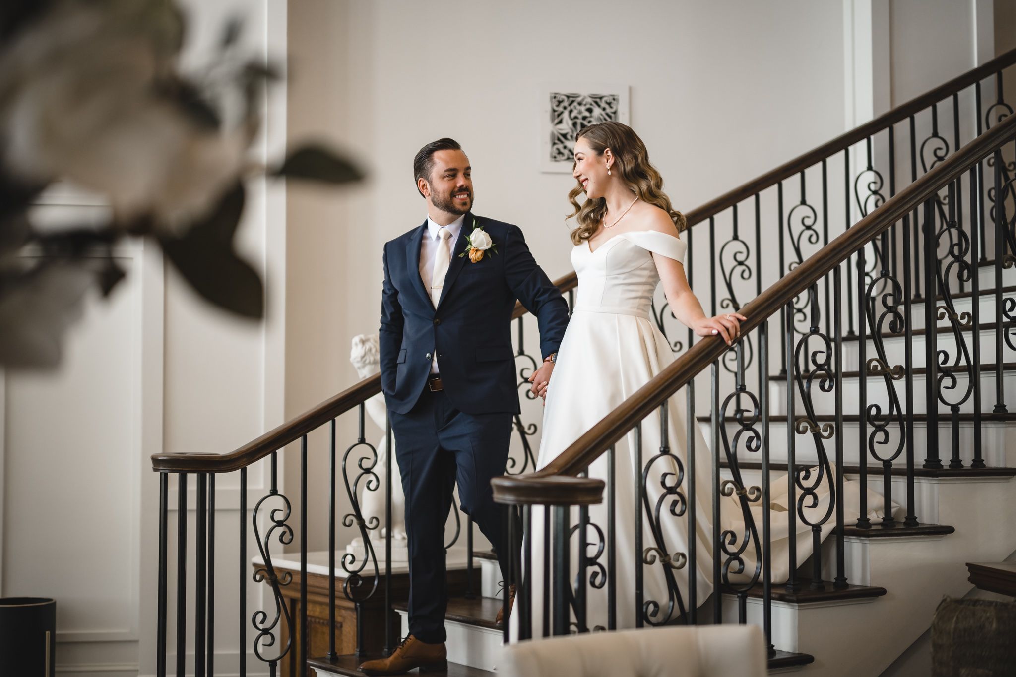 Emotional wedding first look series captured on grand staircase with iron railings.