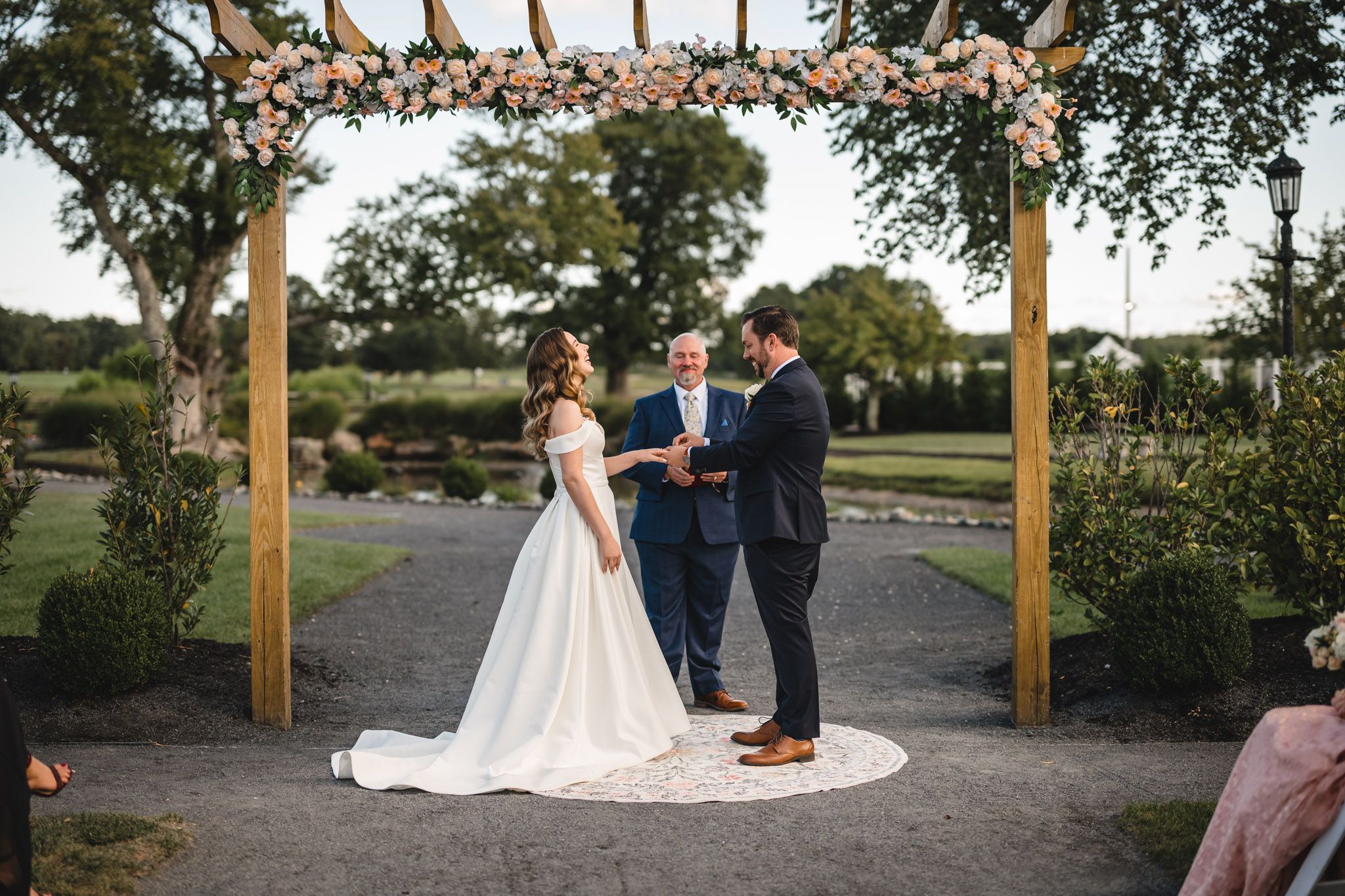 Outdoor wedding ceremony setup with wooden posts and natural landscaping.