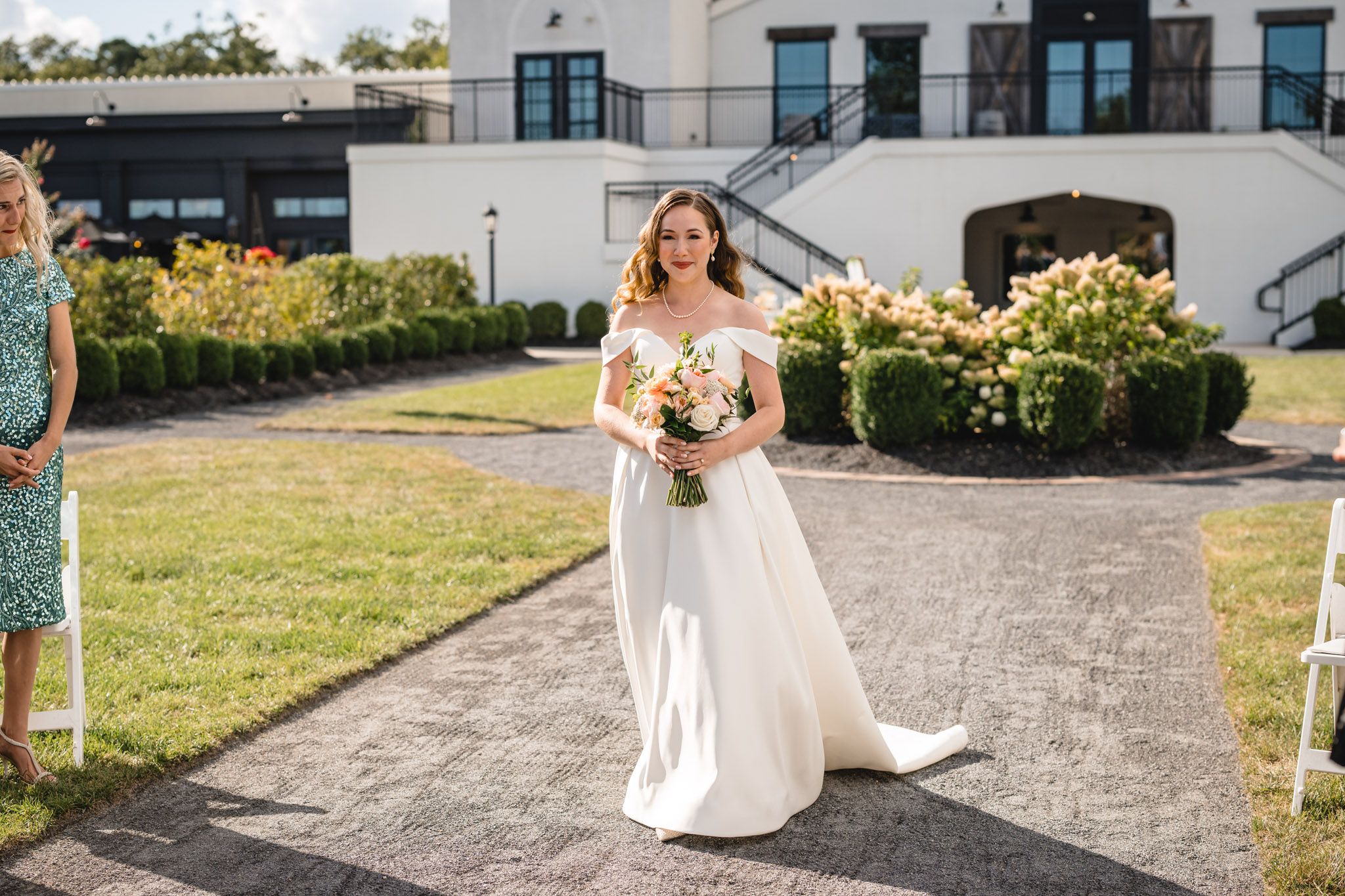 Wedding ceremony location with modern building backdrop and floral arrangements.