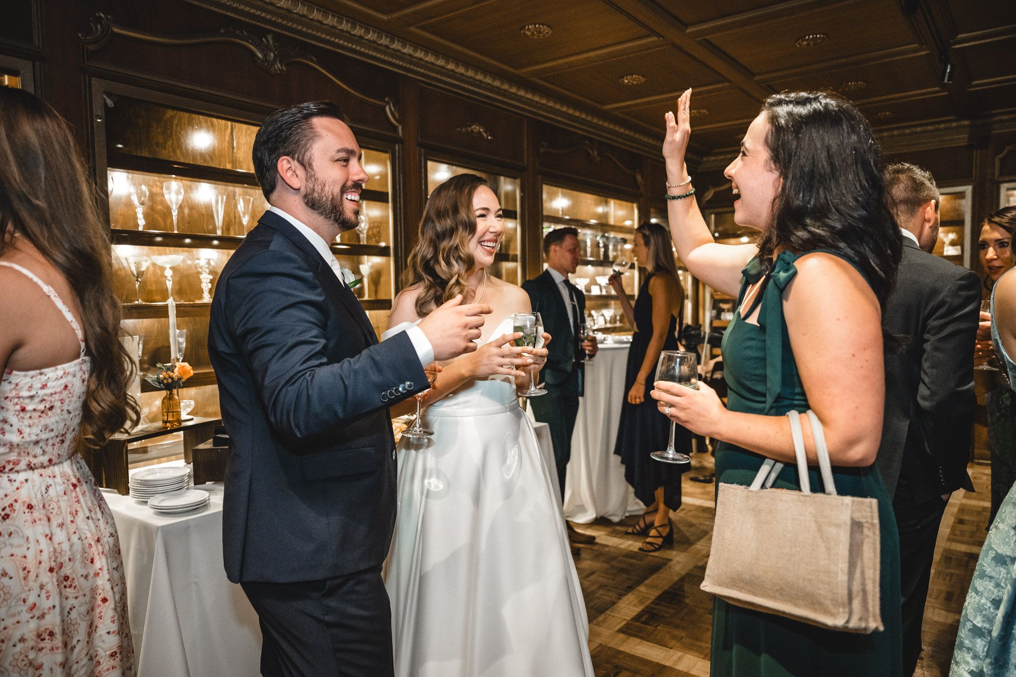Guests celebrate at an elegant wedding reception with exposed brick walls and warm lighting.