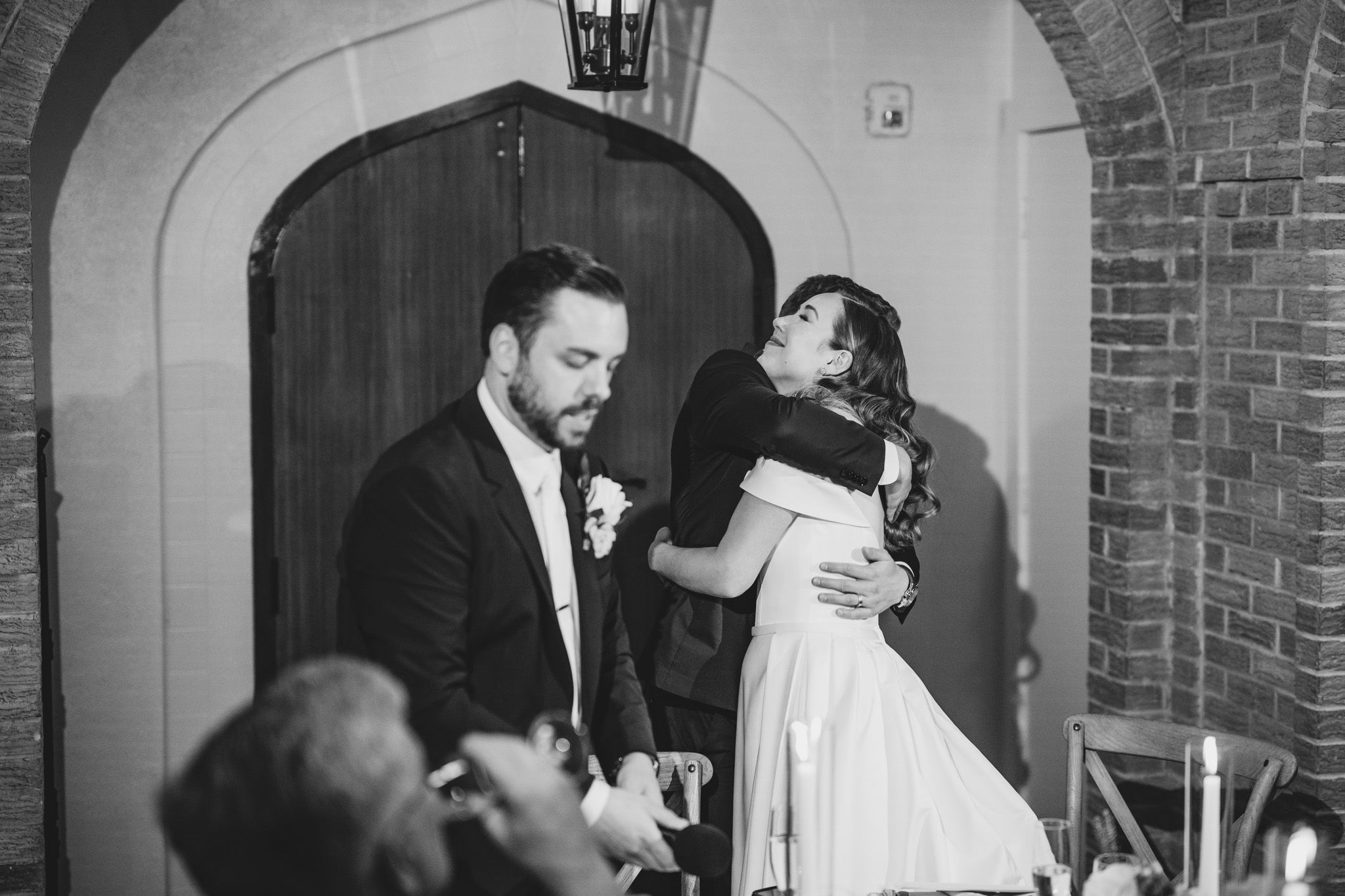 Romantic candlelit wedding reception in a historic venue with exposed brick architecture.