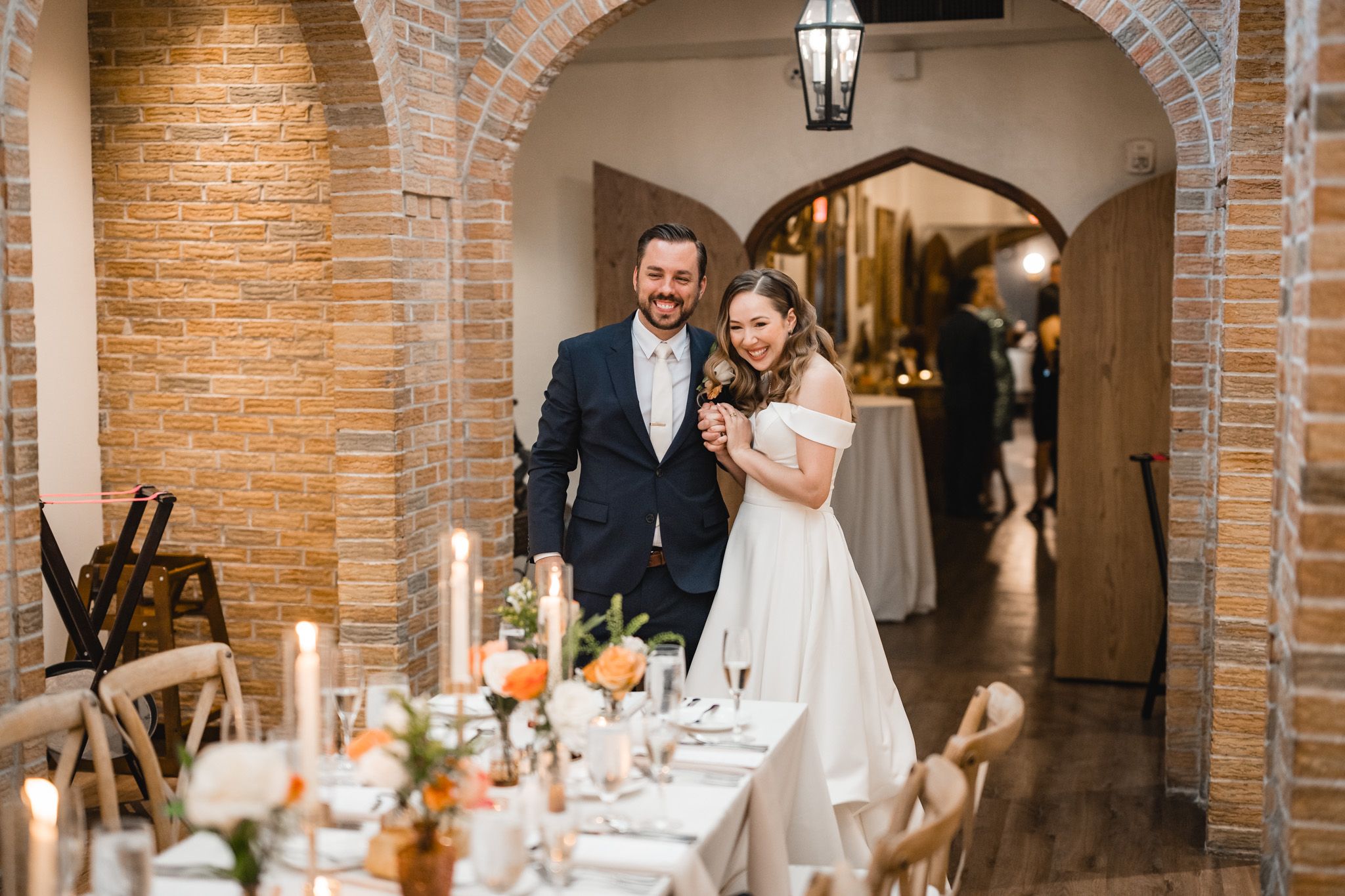 Wedding reception venue with exposed brick archways and romantic lighting.