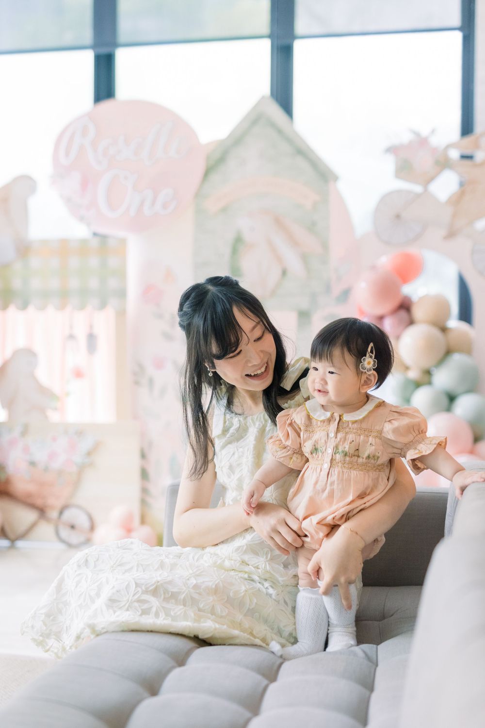 Family sharing tender moments while sitting on a plush white couch in sequence of heartwarming photographs.