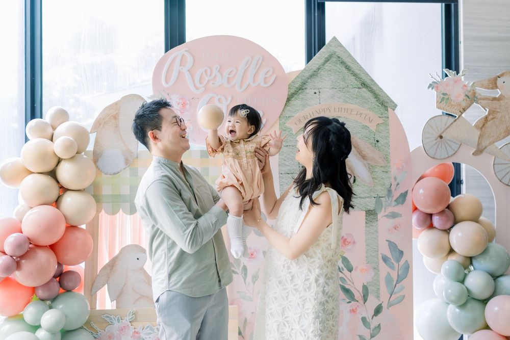 A pastel pink and sage green color scheme wedding setup with elegant balloon decor arrangements and floral elements.
