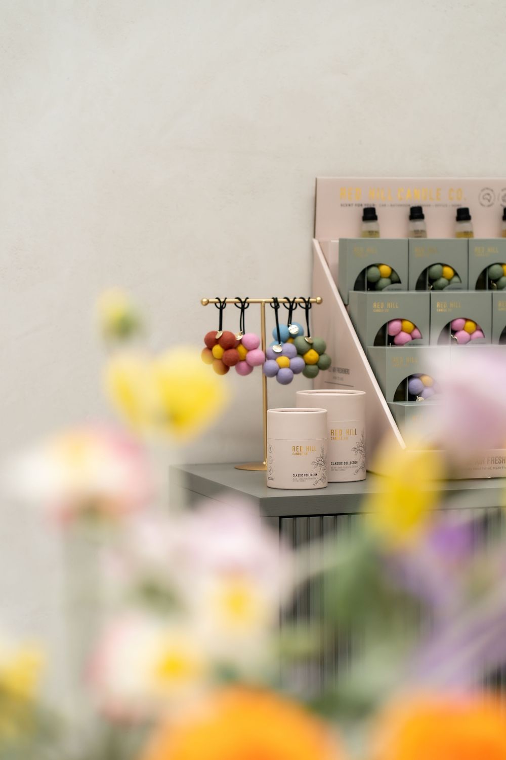 Soft focus bathroom counter with blurred yellow and purple flowers in foreground, showcasing personal care products.