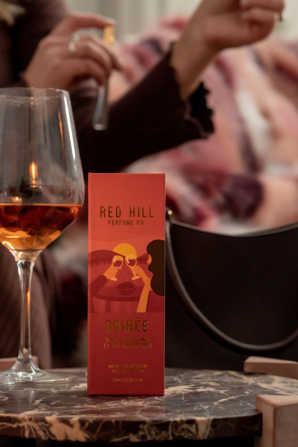 A series of wine glasses and red menus from Red Hill restaurant on a dark rustic table in warm lighting.