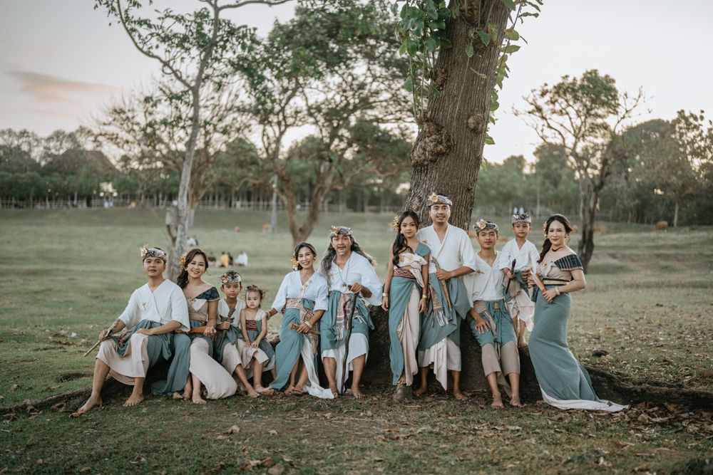 A large group in coordinated blue and white outfits poses together outdoors.