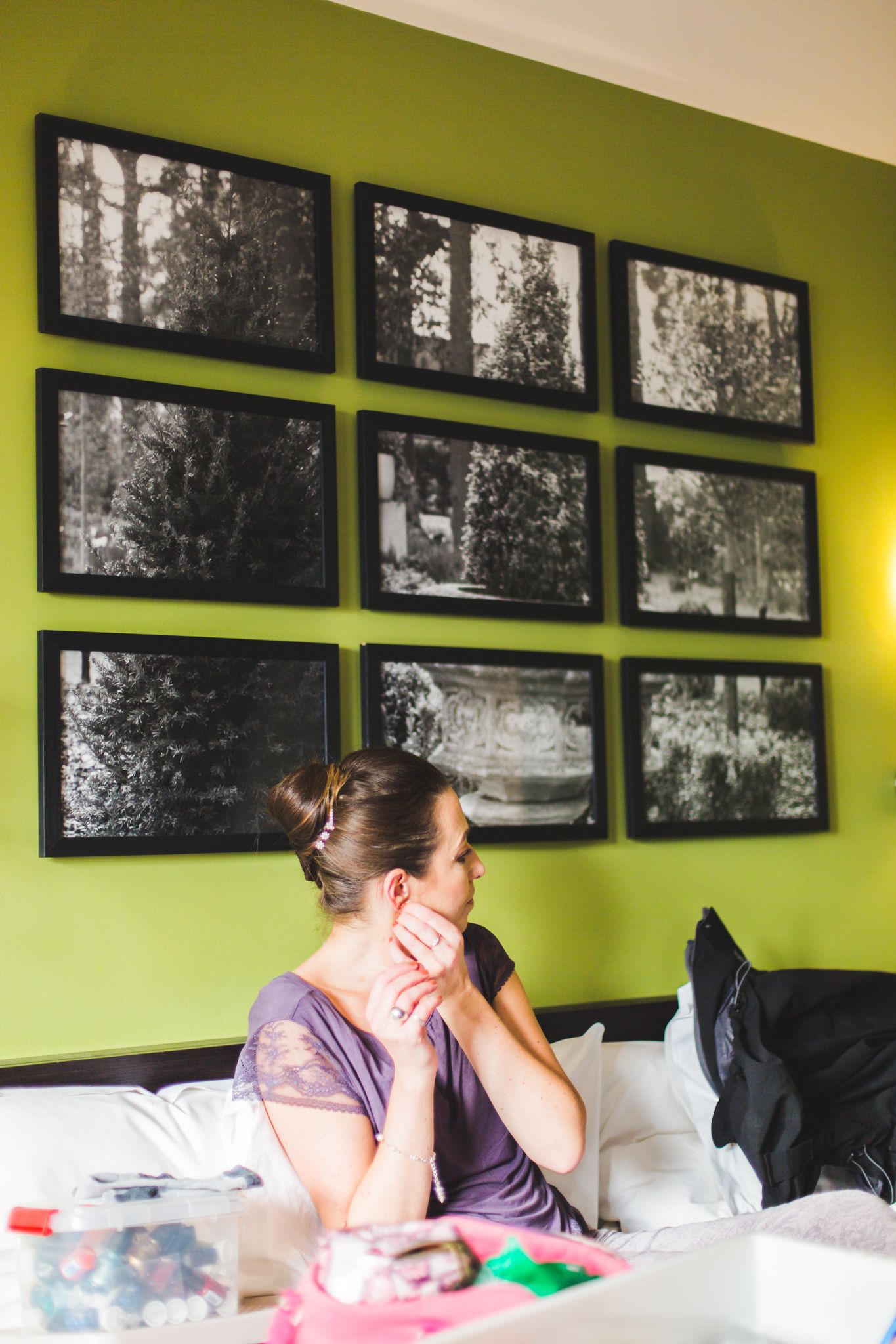 Row of black and white photographs displayed on bright lime green walls above a white couch.