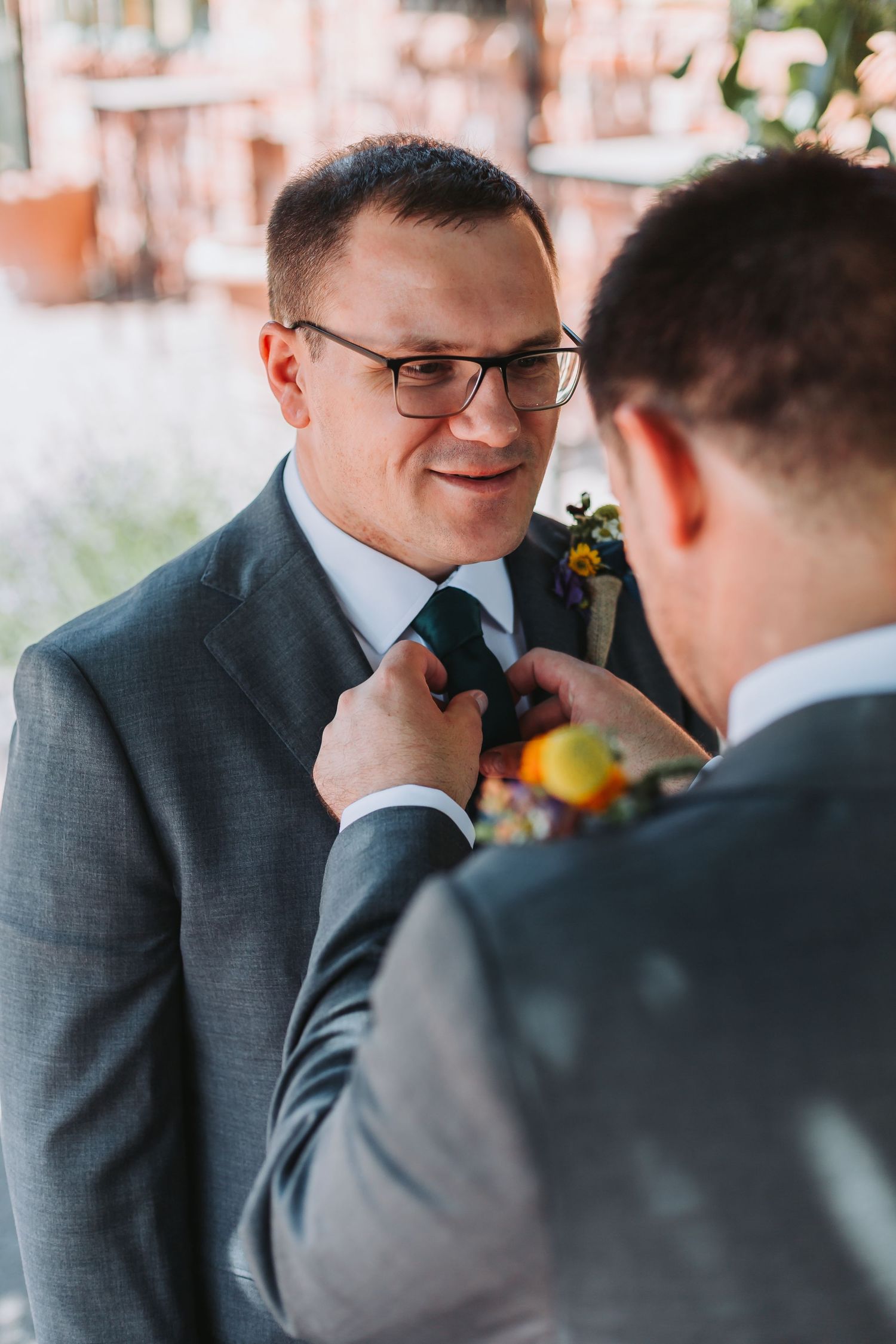 A sequence of wedding photos showing groomsmen in gray suits sharing candid moments during the celebration.