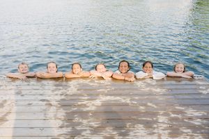 Group enjoying water activities at lake with scenic natural backdrop.