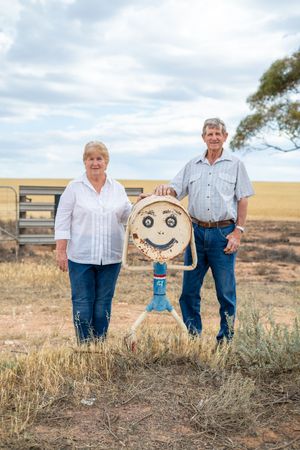 Group portrait composition in a rustic outdoor setting with dry grass and natural lighting.
