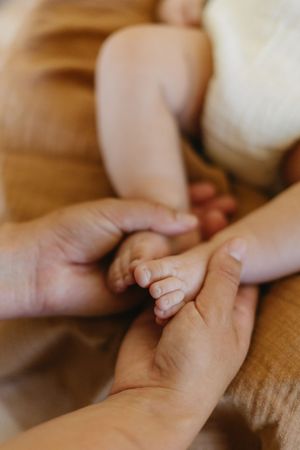 Close-up images of gentle hands holding and touching in an intimate family moment.