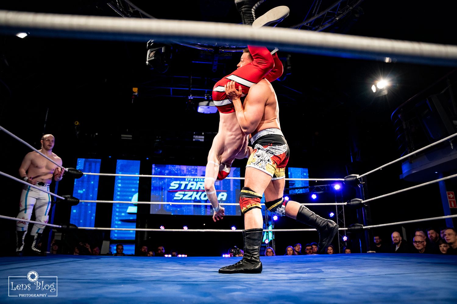 Wrestling match sequence showing athletic maneuvers on blue-lit wrestling ring.