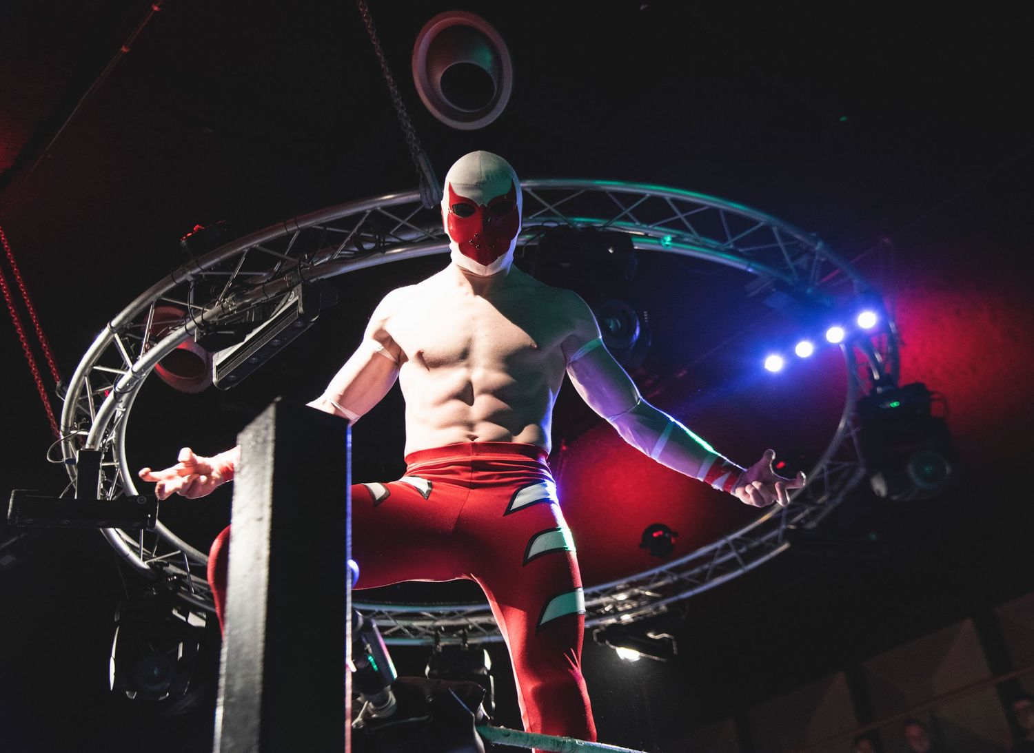 Dark wrestling arena with dramatic lighting and ring setup for professional match.