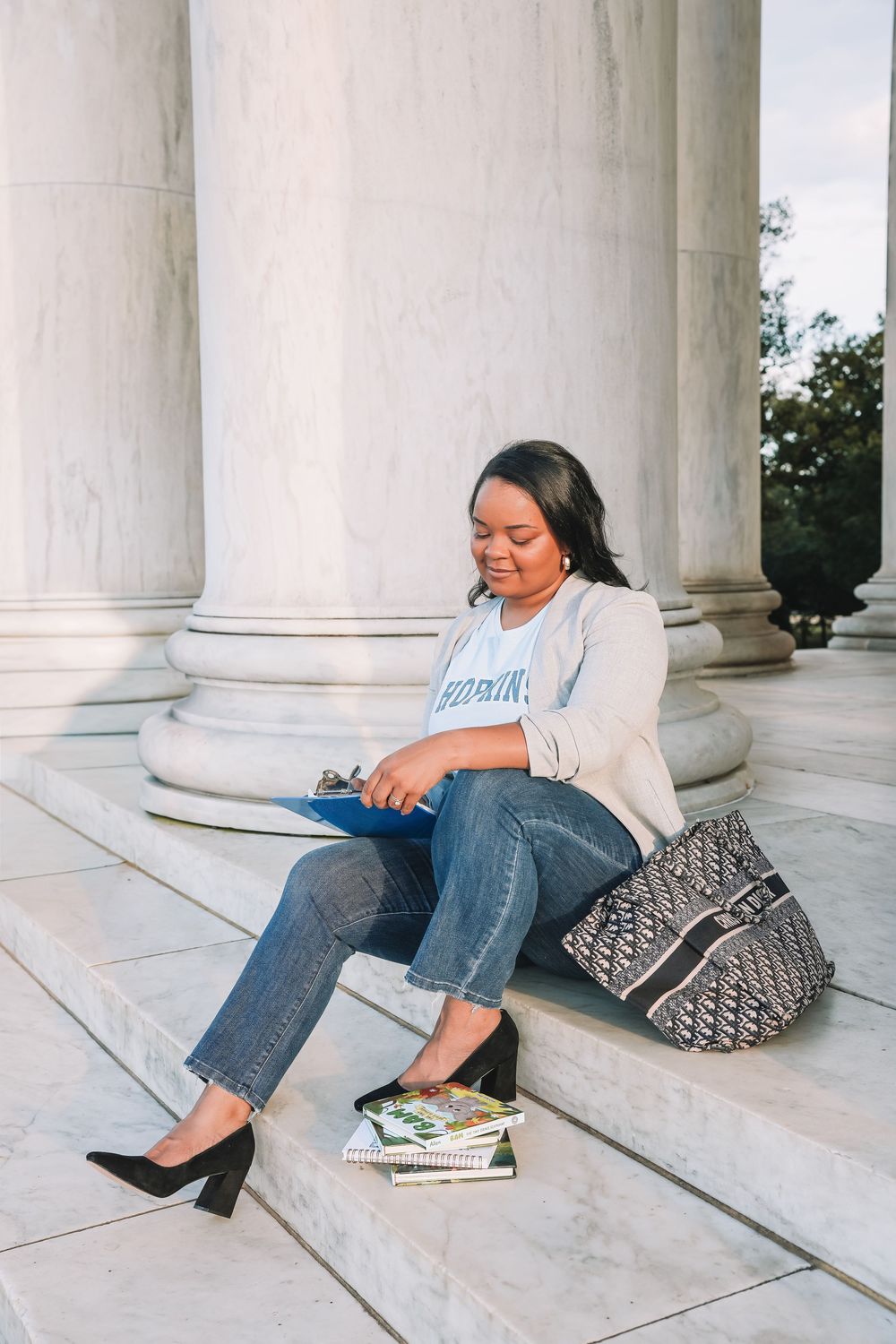 Professional headshot with books on white marble steps | DC graduation portrait