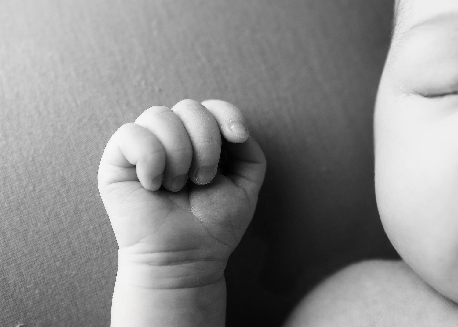 Close-up black and white detail shots of baby hands and features.