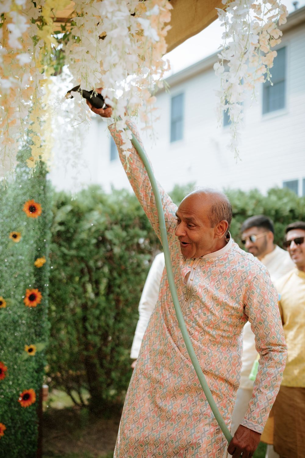 Person in a floral pattern shirt dances joyfully at an outdoor celebration with sunflowers in the background.  Hilton Pearl River NY