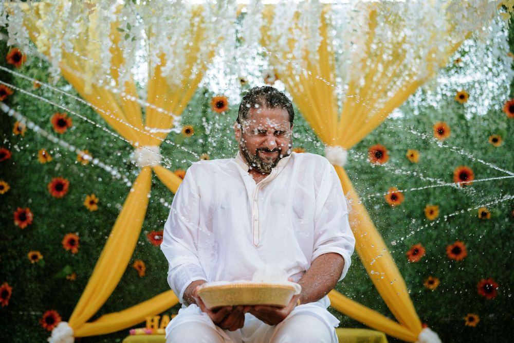 Joyous pre-wedding Haldi ritual with yellow decorations and red flowers in outdoor garden setting.  Hilton Pearl River NY