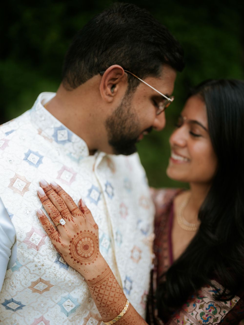 Romantic couple in white traditional dress share intimate moments with intricate henna designs visible.  Hilton Pearl River NY