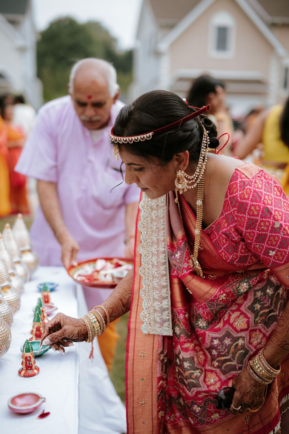 Guests and attendees gather around a dining table at an outdoor event featuring traditional Indian decor and cuisine.  Hilton Pearl River NY