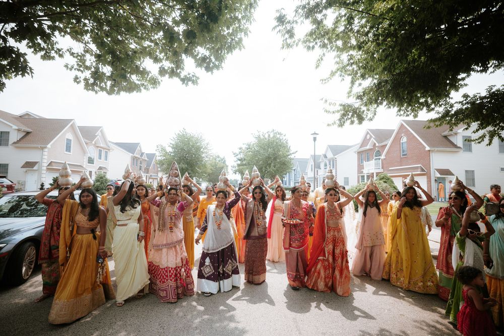 People wearing vibrant sari dresses and traditional South Asian attire gather outdoors for a celebratory procession.  Hilton Pearl River NY