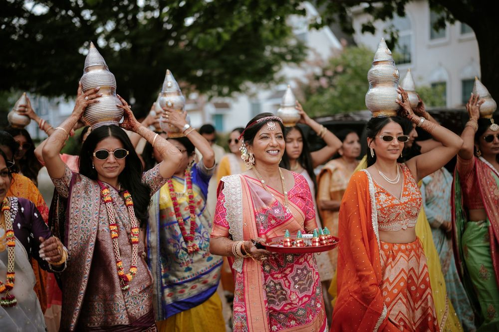 A group of wedding guests in vibrant traditional Indian attire dancing and celebrating at an outdoor ceremony.  Hilton Pearl River NY