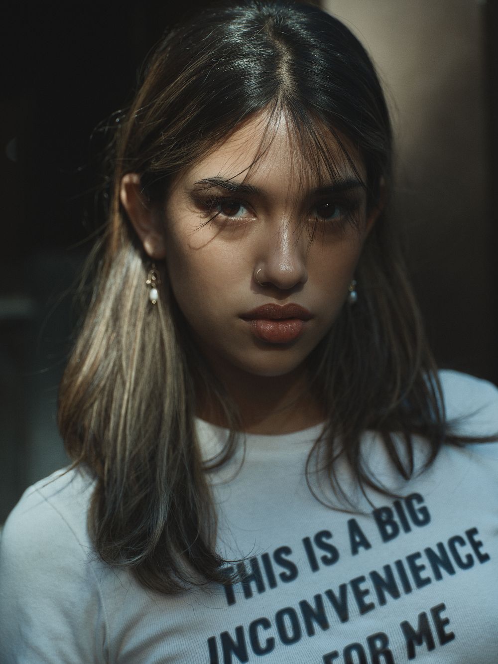A moody portrait series showing someone in a white t-shirt with text against a dark background.