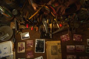 Vintage tavern interior with dimly lit shelves displaying bottles and old photographs creating a cozy rustic atmosphere.