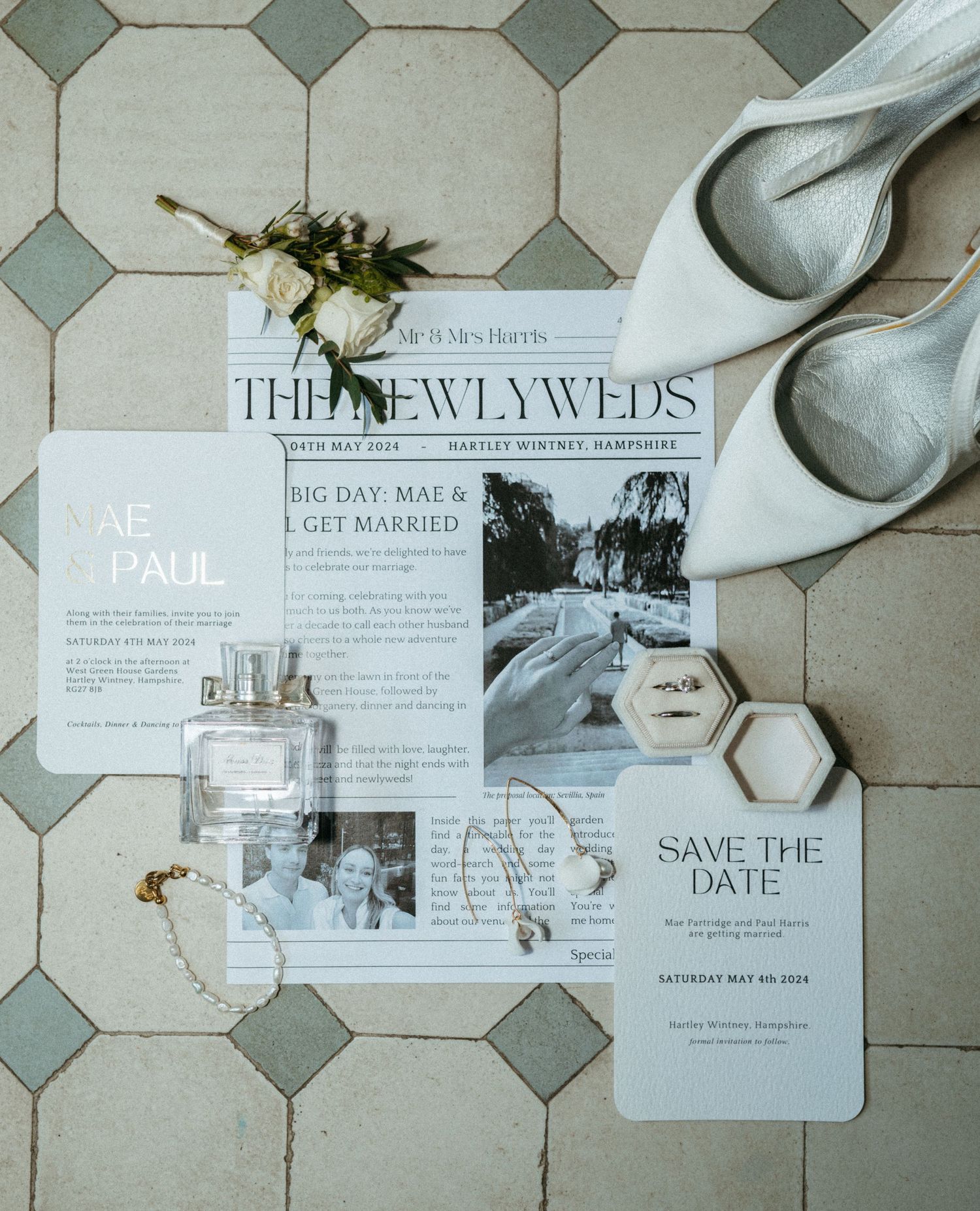 Wedding invitation suite with save the dates and RSVP cards laid out on gray tile floor with decorative ribbons.