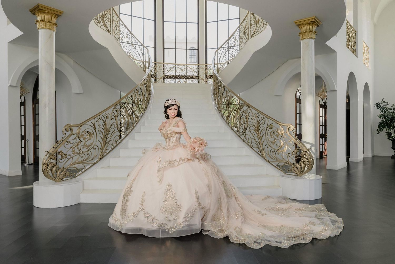 Elegant quince dress displayed in a luxurious white hallway with ornate gold detailing and grand staircase.