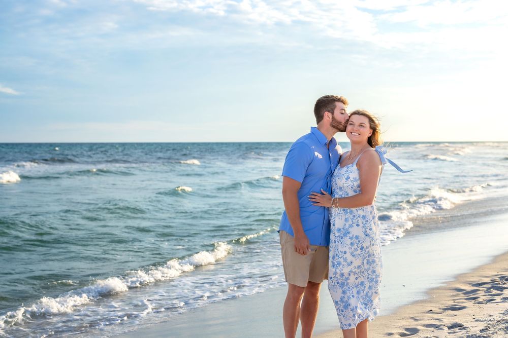 A romantic beach scene at sunset with a couple embracing near the ocean waves in Florida.