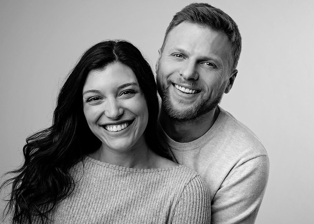 A series of black and white photos showing a happy couple in casual sweaters embracing and smiling together.