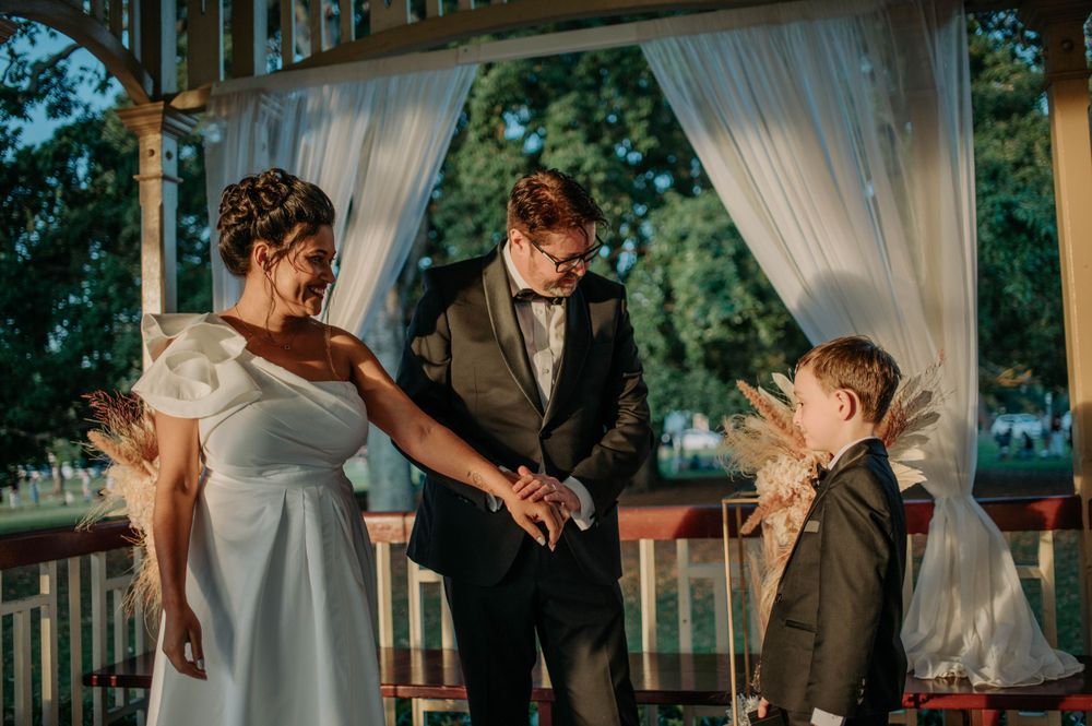 A heartwarming moment shared during a wedding ceremony in a decorated gazebo.