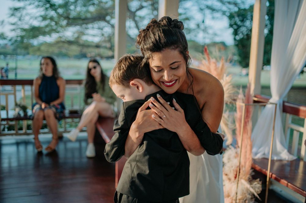 A joyful emotional embrace shared during a wedding celebration in an outdoor gazebo.