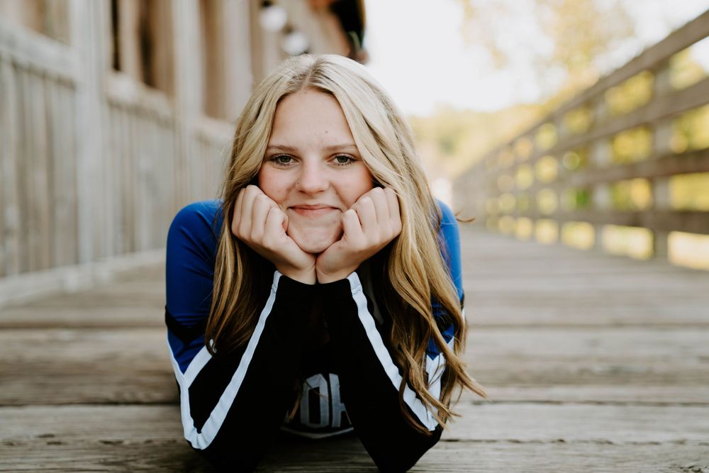 Cheerful portrait on wooden boardwalk wearing blue and white athletic wear.