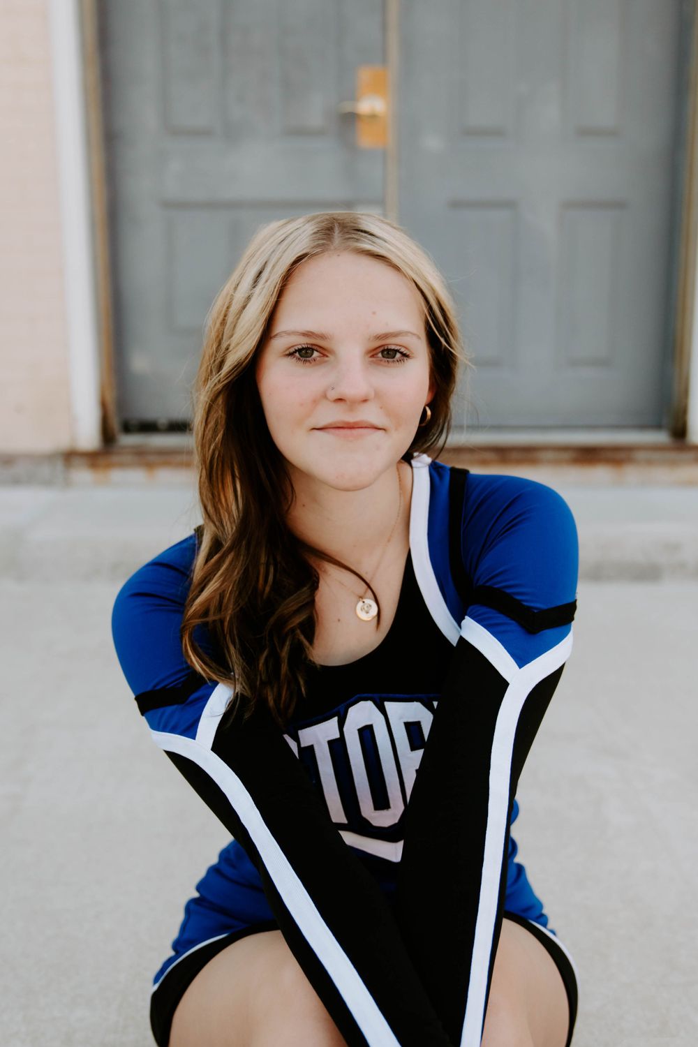 Portrait series showing someone wearing a blue and white varsity jacket against a light background.